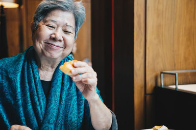 Senior woman eating breakfast at home