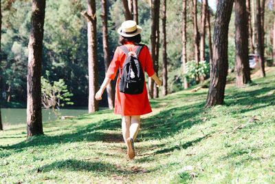 Rear view of woman walking on field