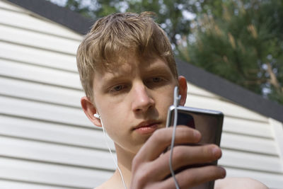Portrait of young man using mp3 player