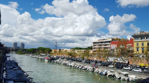 Panoramic view of river passing through city against cloudy sky