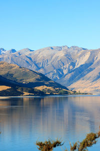 Scenic view of lake and mountains against blue sky