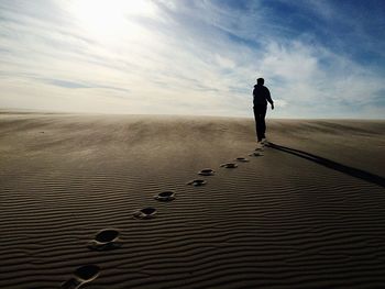 Rear view of woman up sand dune