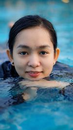 Portrait of young woman swimming in pool