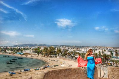 Woman on beach against blue sky