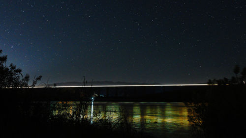 Scenic view of lake against sky at night