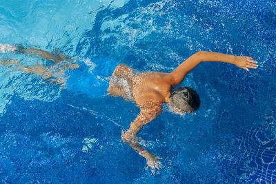 High angle view of boy swimming in pool