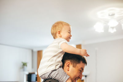 Side view of boy playing with toy at home