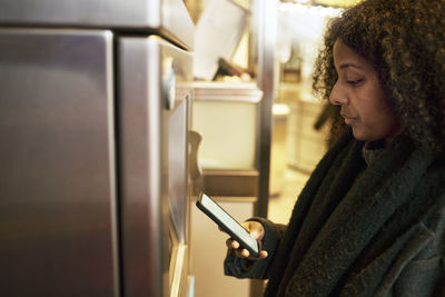 Woman standing in front of ticket machine