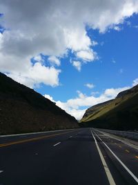 Empty road by mountain against sky