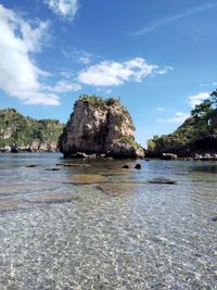 Rock formation on beach against sky