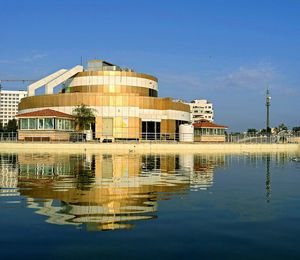 Reflection of built structure in water against clear sky