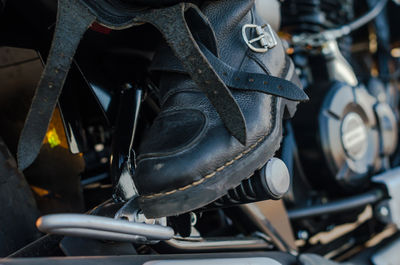 Low section of biker sitting on motorcycle