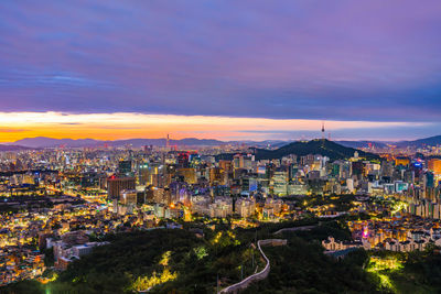 High angle view of illuminated buildings against sky at sunset