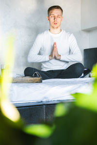 Portrait of young man sitting on table