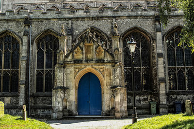 Closed blue arch door of church during sunny day