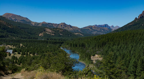 Scenic view of lake and mountains against blue sky