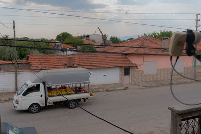 Cars on street by buildings against sky