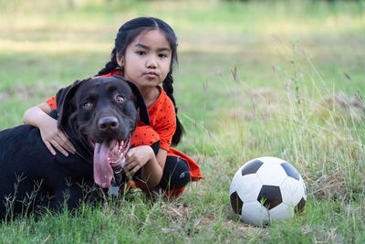 Portrait of dog with ball on field