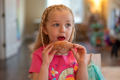 Girl looking away while eating food