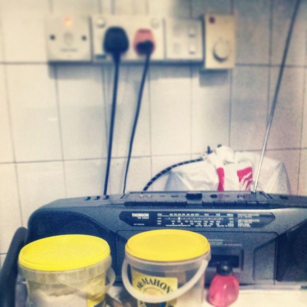 indoors, food and drink, yellow, still life, container, drink, close-up, table, coffee cup, domestic kitchen, bottle, kitchen, high angle view, no people, technology, communication, day, refreshment, equipment, cup