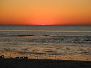 Scenic view of sea against orange sky