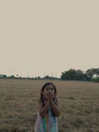 Woman standing on field against clear sky