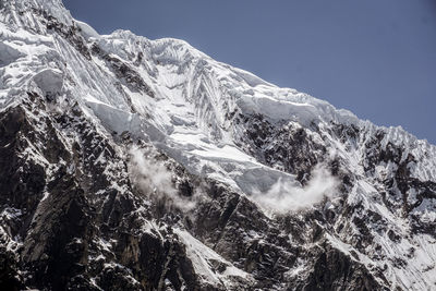 Low angle view of snowcapped mountains against clear sky