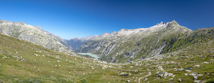 Scenic view of snowcapped mountains against clear blue sky