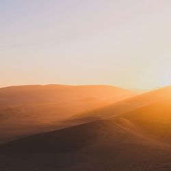 Scenic view of desert against sky during sunset