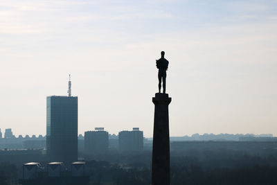 Silhouette of city against sky during sunset