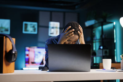 Side view of woman using laptop at table