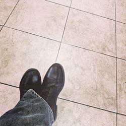 Low section of woman standing on tiled floor