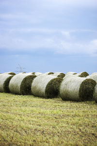 Hay bales on field against sky