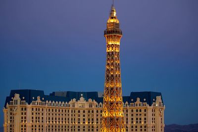 Low angle view of illuminated buildings against blue sky