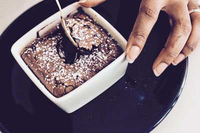 Close-up of hand holding ice cream in bowl