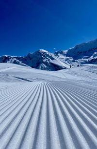 Scenic view of snowcapped mountains against clear blue sky