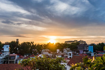 Residential district against sky at sunset