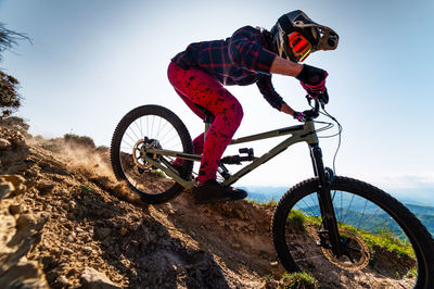 Mountain biker riding down a grassy slope. enduro mountain bike. mtb against a mountain landscape