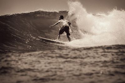 Full length of man splashing water in sea