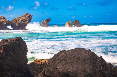 Panoramic view of rocks on beach against sky