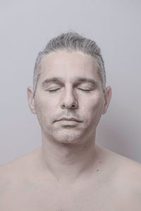 Portrait of shirtless man against white background