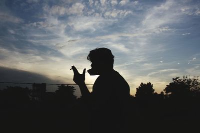 Silhouette man standing against sky during sunset 