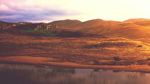 Scenic view of dramatic landscape against sky during sunset