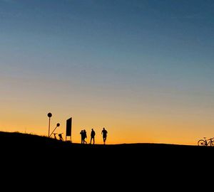 Silhouette people against clear sky during sunset