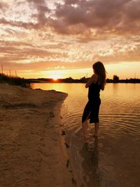 Full length of man standing on beach during sunset