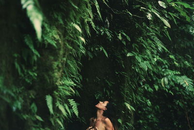 Sensuous shirtless woman against trees