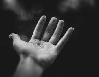 Close-up of human hand against black background