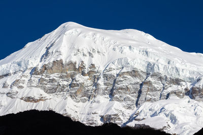 Scenic view of snowcapped mountains against clear sky