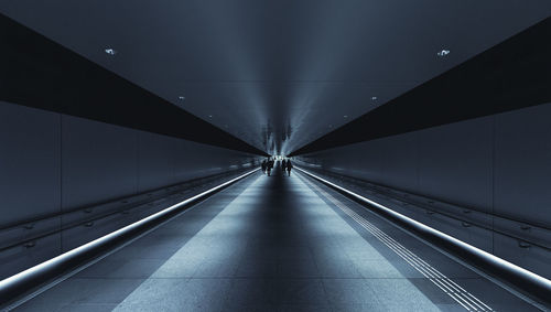 People walking in illuminated subway station platform