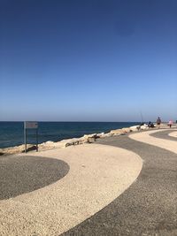 Scenic view of beach against clear blue sky